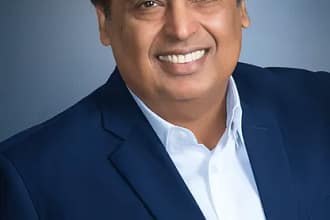 Mukesh Ambani indian billionaire with smiling face wearing white shirt and blue coat
